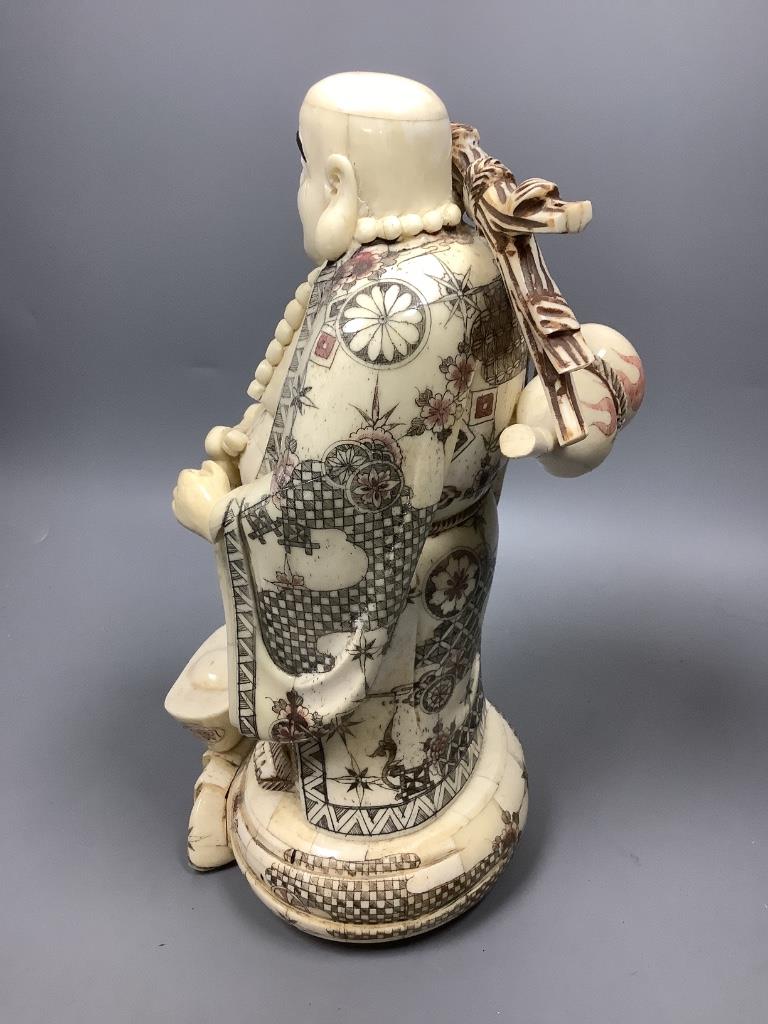 A Chinese engraved and stained bone figure of Budai, height 29cm